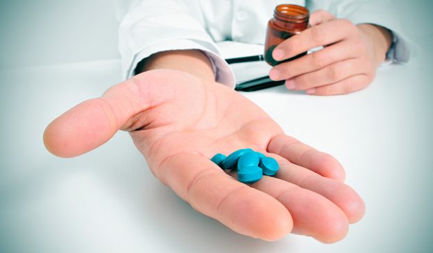 la main tenue avec des pilules bleues, qui aident a ameliorer les performances sexuelles
